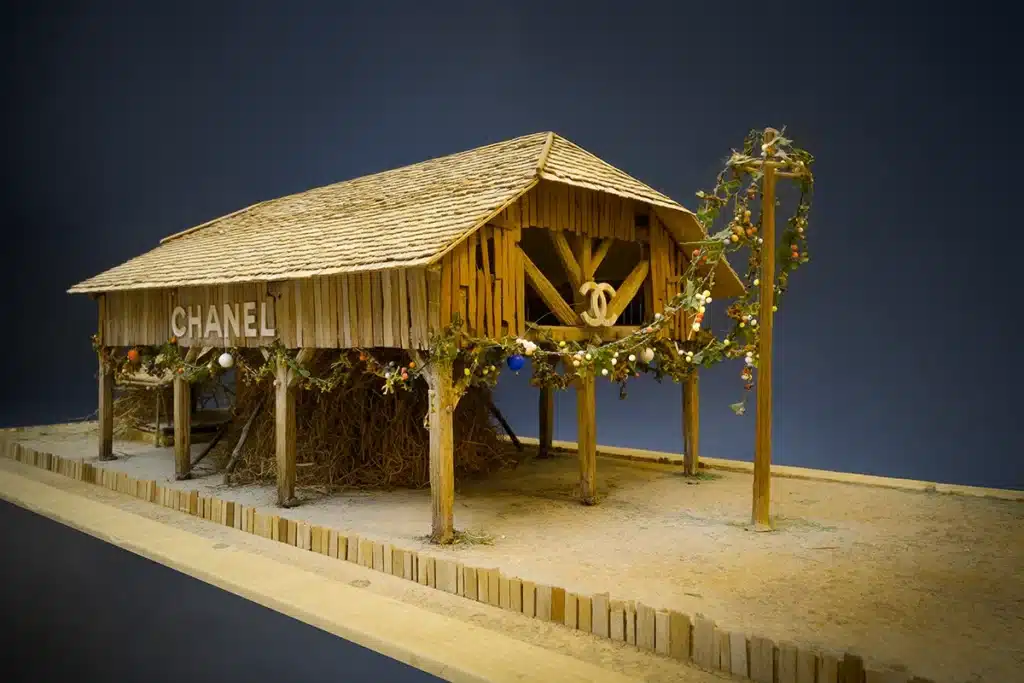 Maquette d'une ferme en bois avec un sol de paille et de terre.