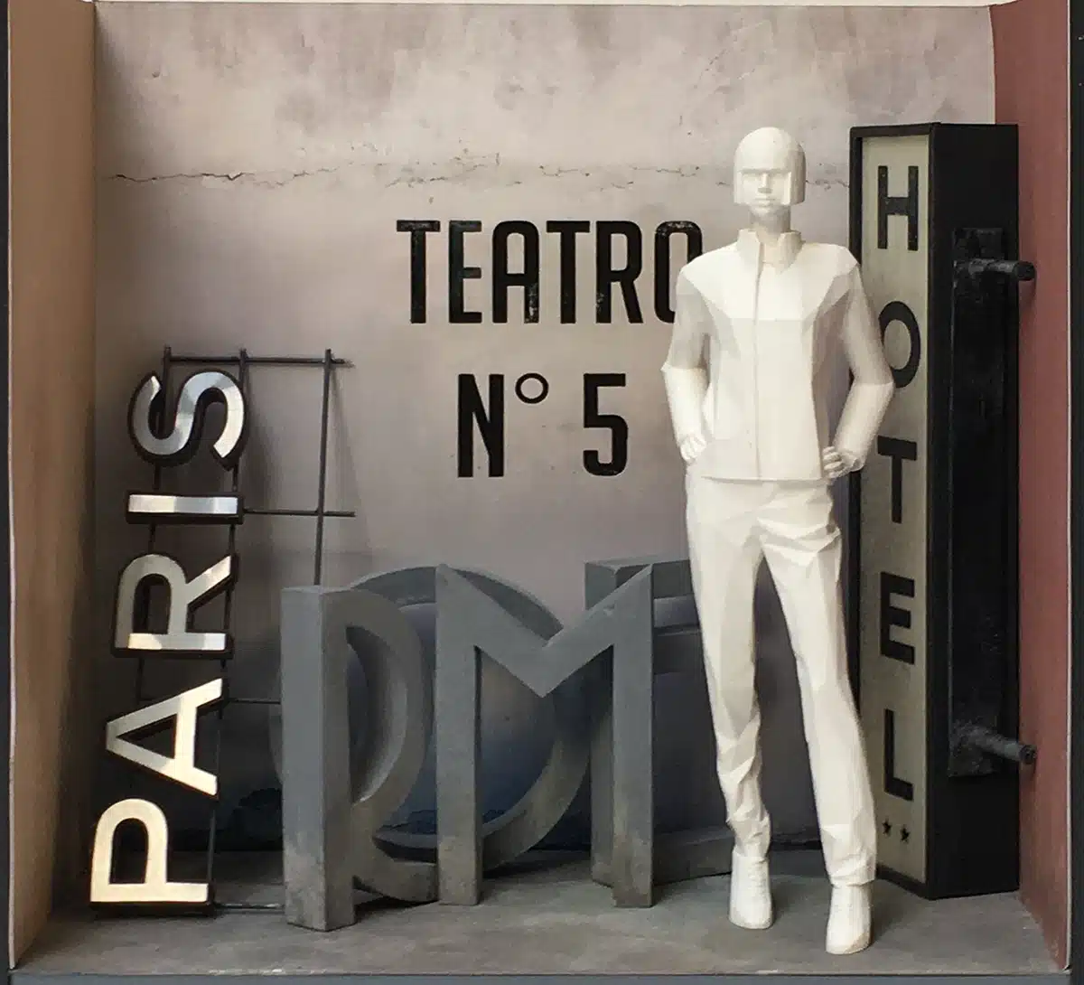 Maquette d'une vitrine inspirée du cinéma italien et de Cinecittà, mêlant grandes lettres sculptées (“PARIS”, “ROME”, “HOTEL”), néons rétro et décor patiné façon studio de tournage. Les mannequins, stylisés en blanc, se détachent dans une ambiance Paris à Rome, entre théâtre, hôtel et plateau de film.